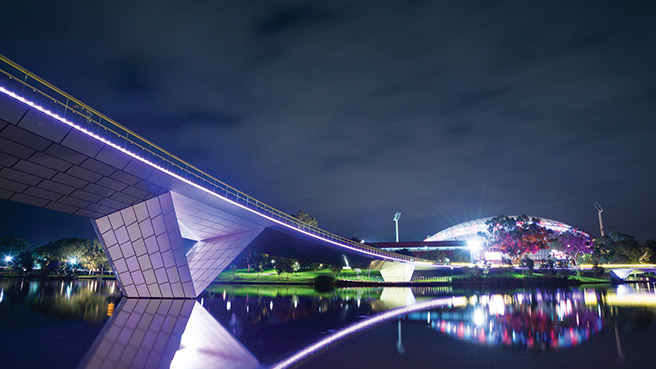 Footbridge over the River Torrens and Adelaide Oval at night.
